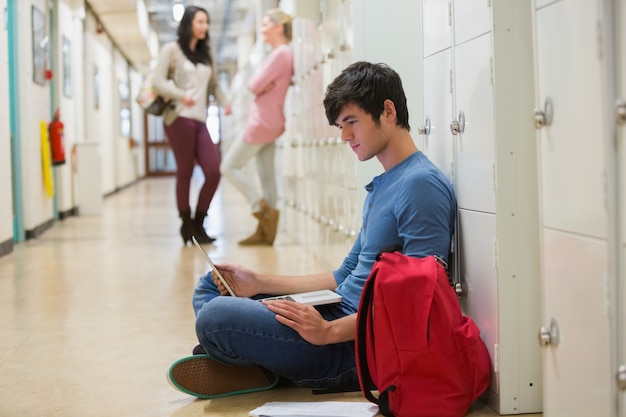 Zdjęcie skoncentrowany student siedzi na podłodze