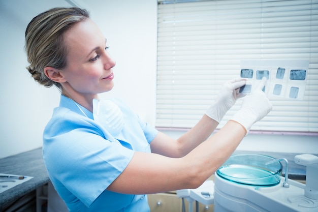 Skoncentrowany żeński dentysta patrzeje promieniowanie rentgenowskie