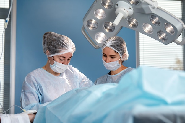 Skoncentrowany Zespół Chirurgiczny obsługujący pacjenta na sali operacyjnej