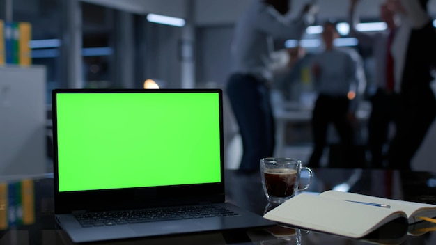 Skoncentruj się na laptopie z zielonym ekranem Koledzy tańczą i bawią się na niewyraźnym tle