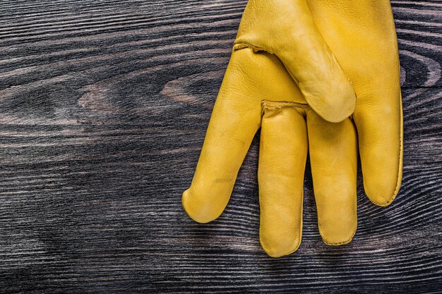 Skórzana żółta rękawica ochronna na koncepcji konserwacji zabytkowej deski drewnianej