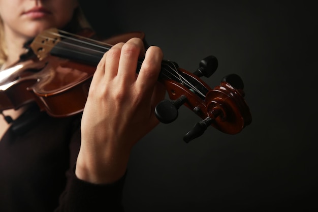 Skrzypek grający na skrzypcach na ciemnym tle