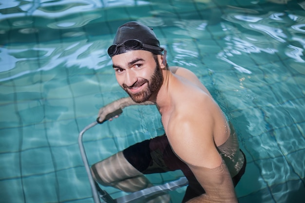 Skupiający się mężczyzna robi podwodnemu rowerowi w basenie