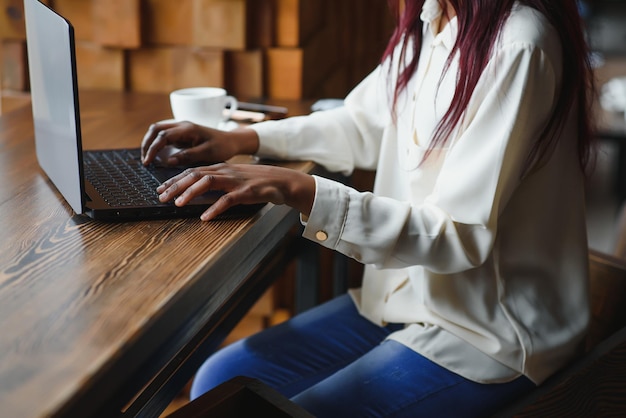 Skupiona młoda afroamerykańska bizneswoman lub studentka patrząca na laptopa, poważna czarna kobieta pracująca lub studiująca z komputerem, prowadząca badania lub przygotowująca się do egzaminu online