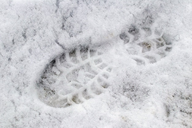 Zdjęcie Ślady butów na mokrym śniegu, zimowe tło