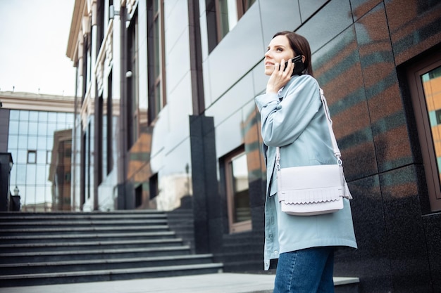 Śliczna biznesowa dama rozmawia przez telefon na schodach Nowoczesny styl życia