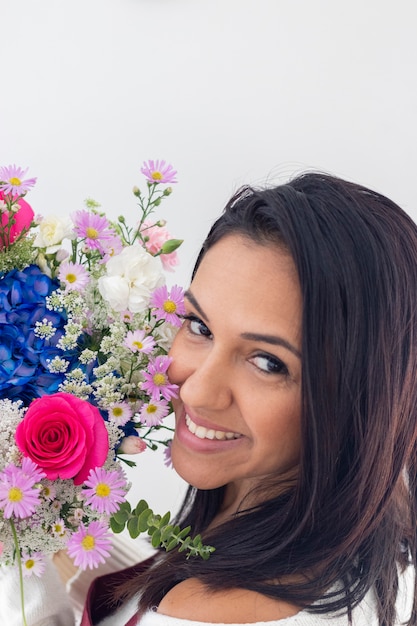 Śliczna brunetki kobieta cieszy się jej bukiet kwiaty