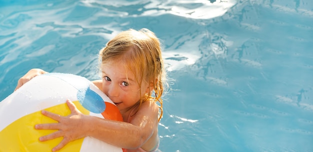 Śliczna dość figlarnie szczęśliwa kaukaska blondynka dwuletnia dziewczynka childkid berbeć bawiący się piłką havi