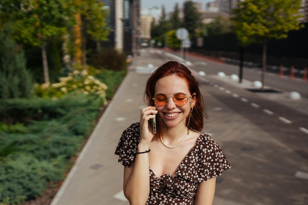 Śliczna dziewczyna rozmawia przez telefon komórkowy na tle nowoczesnego miasta