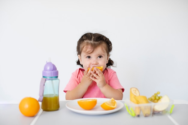 Zdjęcie Śliczna dziewczyna siedzi jej pomarańcze i cieszy się