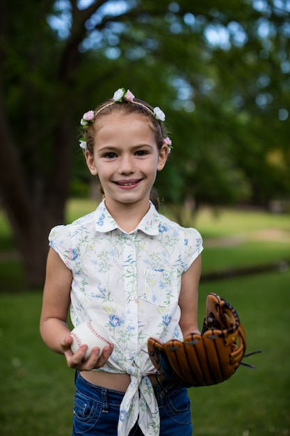 Śliczna dziewczyna trzyma baseball w parku