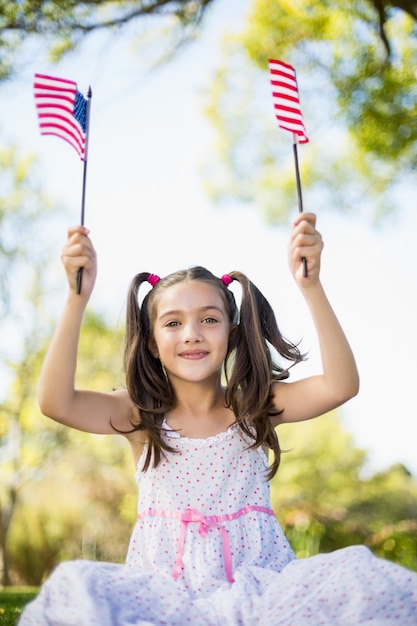Śliczna dziewczyna trzyma flaga amerykańskie