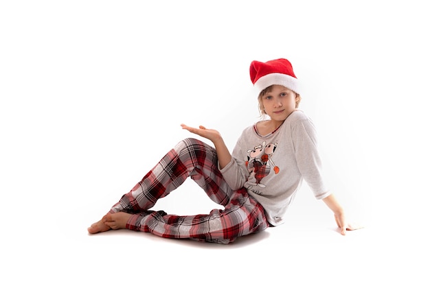 Śliczna dziewczyna w santa hat. Pojęcie świąt Bożego Narodzenia. Obchody Nowego Roku. Piękna dziewczyna w czerwonej czapce Mikołaja świętuje Boże Narodzenie, bawiąc się. Miejsce na tekst.