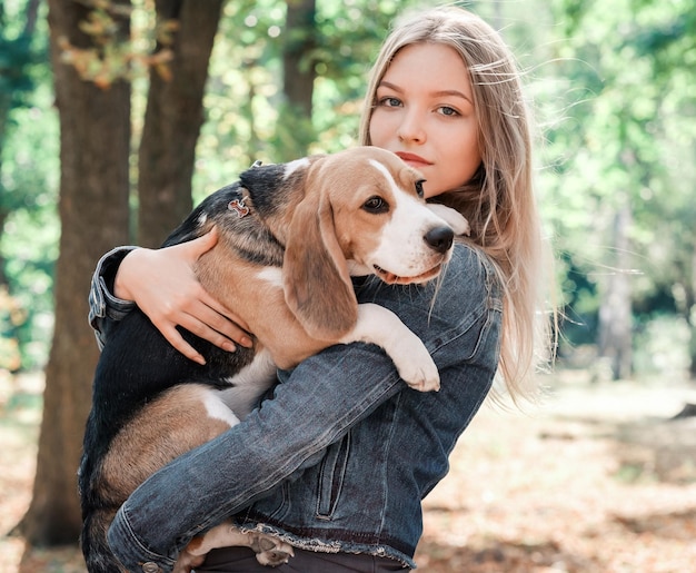 Śliczna dziewczyna z psem rasy beagle w jesiennym parku