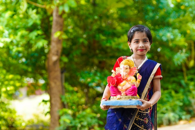 Śliczna indyjska mała dziewczynka świętuje festiwal Lord Ganesha