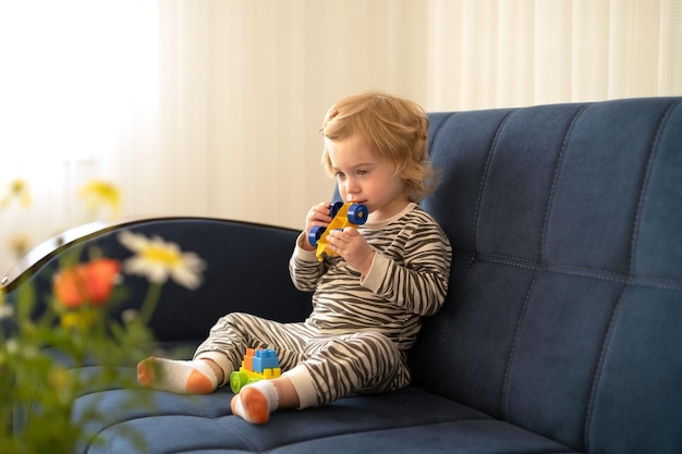 Śliczna Kaukaska Blondynka Dziewczynkamaluch Niemowlę Urocze Dziecko 12 Lat Na Kanapie Gryzienie Majsterkowicza Zabawka W Nowoczesnym Przytulnym Wnętrzu W Domuprzemyślana Koncepcja Ząbkowania Dziecka