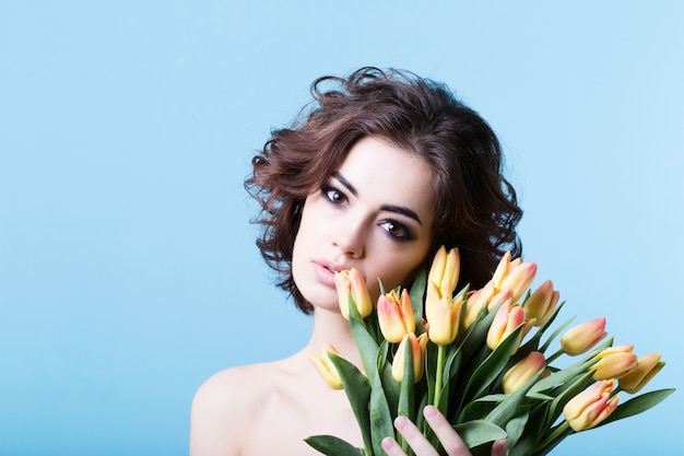Śliczna kobieta przedstawia Ci wiosenny bukiet kwiatów