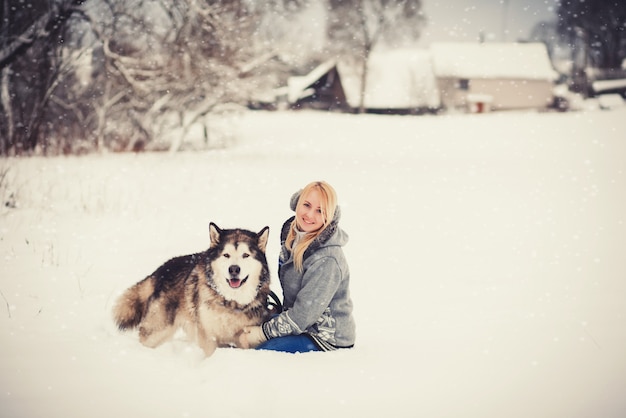 Śliczna kobieta w puloweru obsiadaniu z psem