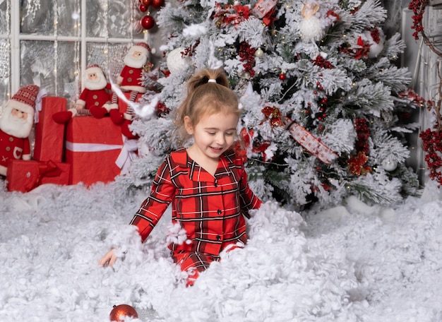 Śliczna mała dziewczynka bawi się w świątecznym pokoju. koncepcja wesołych świąt.