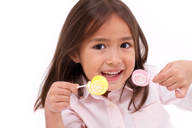 Śliczna mała dziewczynka bawić się, je cukrowej galarety słodkiego cukierek