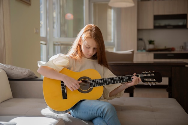 Zdjęcie Śliczna mała dziewczynka gra na gitarze