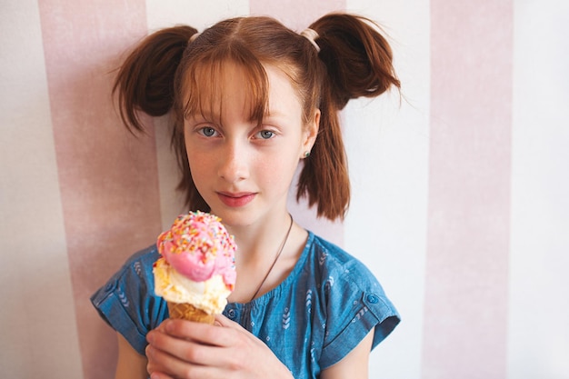 Śliczna mała dziewczynka je lody w stołówce Dziecko trzymające lody Dziecko i słodycze