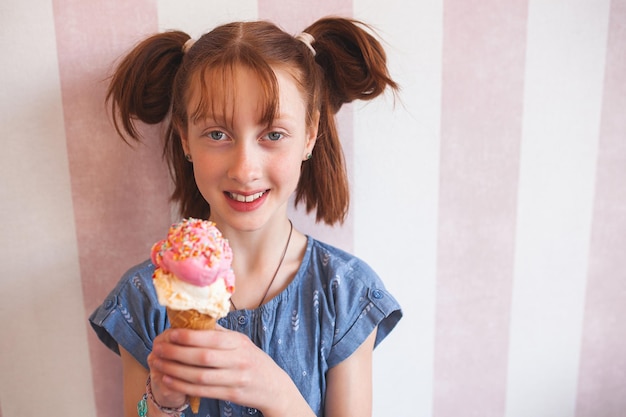 Śliczna mała dziewczynka je lody w stołówce Dziecko trzymające lody Dziecko i słodycze