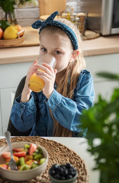 Śliczna mała dziewczynka je sałatkę owocową