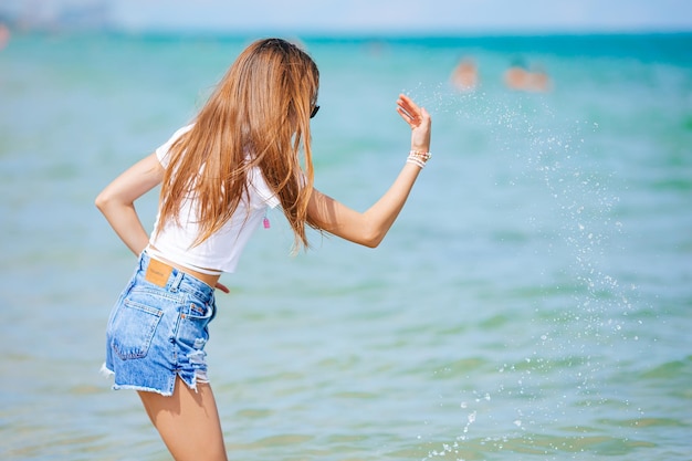 Śliczna Mała Dziewczynka Na Plaży Podczas Rozpryskiwania Wakacji Na Karaibach