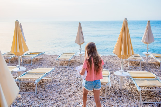 Śliczna mała dziewczynka przy plażą podczas wakacje