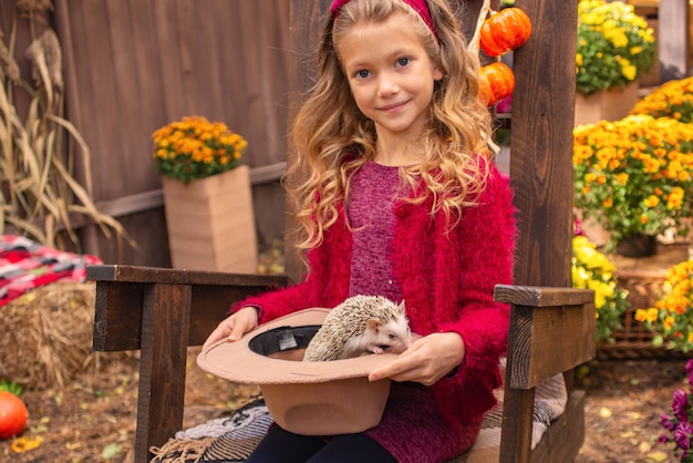śliczna mała dziewczynka trzymająca jeża w ramionach jesienny portret