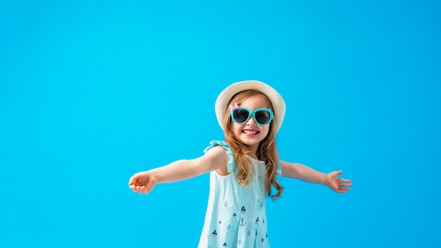 Śliczna mała dziewczynka w pozach sukienka, kapelusz i okulary przeciwsłoneczne