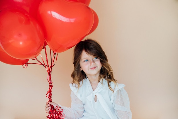 Śliczna mała dziewczynka z balonami w kształcie serca na Walentynki rodzinne prezenty miłości na święta