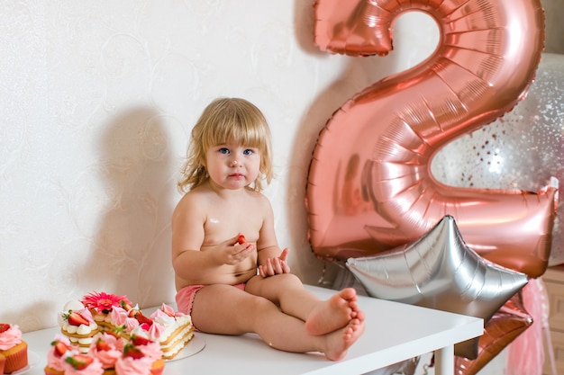 Śliczna mała dziewczynka z dekoracjami urodzinowymi