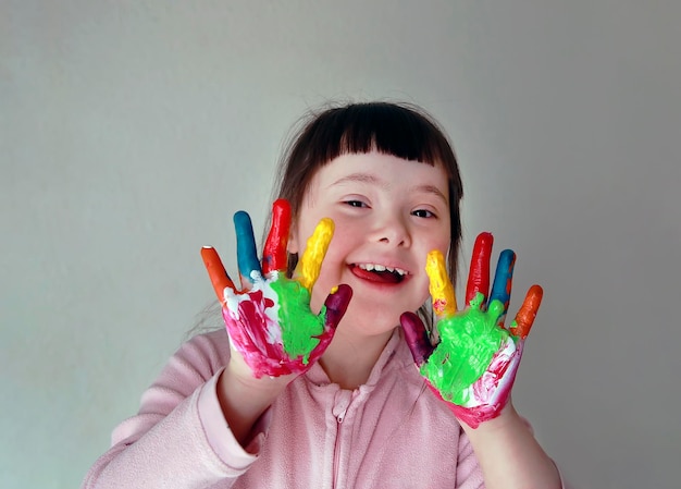 Śliczna mała dziewczynka z malowanymi rękami. Na białym tle na szarym tle.