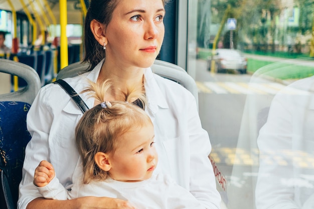 Śliczna mała dziewczynka z matką w autobusie