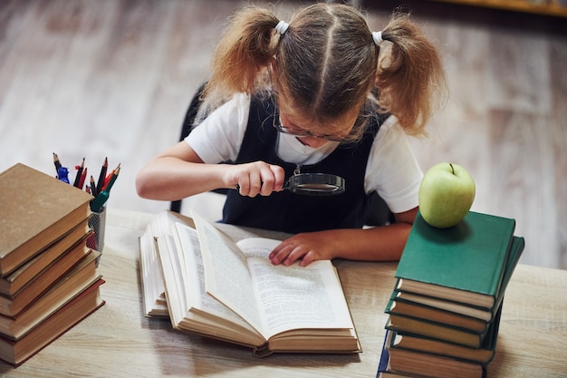 Śliczna Mała Dziewczynka Z Warkoczykami Jest W Bibliotece