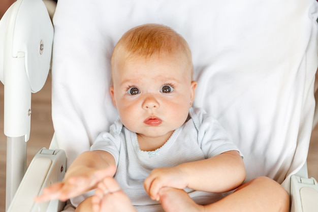 Śliczna mała noworodka dziewczynka z uśmiechniętą twarzą patrząca w kamerę na białym tle niemowlę niemowlę odpoczywające...