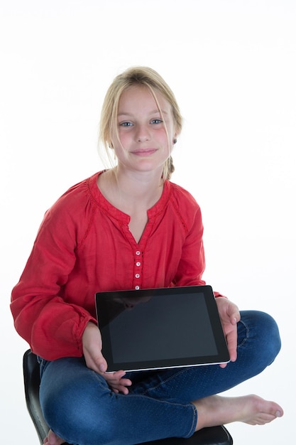 Śliczna mała uśmiechnięta dziewczyna przy użyciu komputera typu tablet