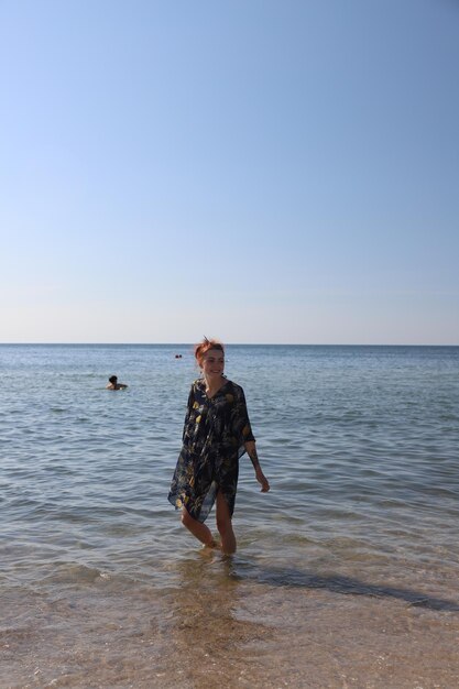 Zdjęcie Śliczna młoda dziewczyna stojąca w wodzie morza uśmiechnięta