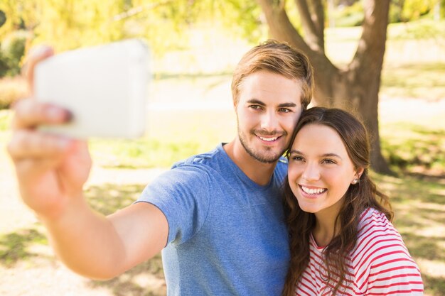 Śliczna para robi selfie w parku