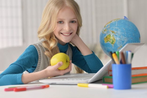 Śliczna studentka z książką i laptopem w klasie