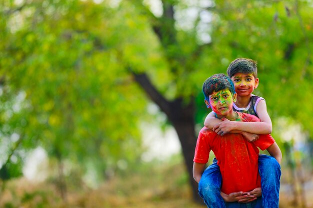 Śliczne indyjskie małe dzieci bawiące się holi. Holi to festiwal kolorów w Indiach