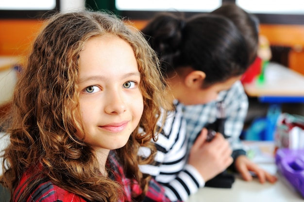 Zdjęcie Śliczne piękne dzieci w wieku szkolnym w clasroom o działalności edukacyjnej