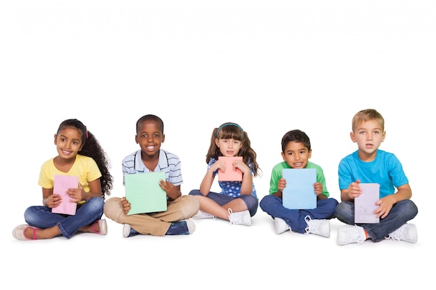 Śliczni dzieci siedzi kolor papier i trzyma