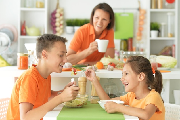 Śliczny brat i siostra razem degustują sałatkę w kuchni w domu