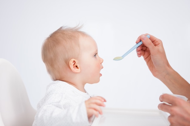 Śliczny dziecka obsiadanie na highchair podczas gdy karmiący