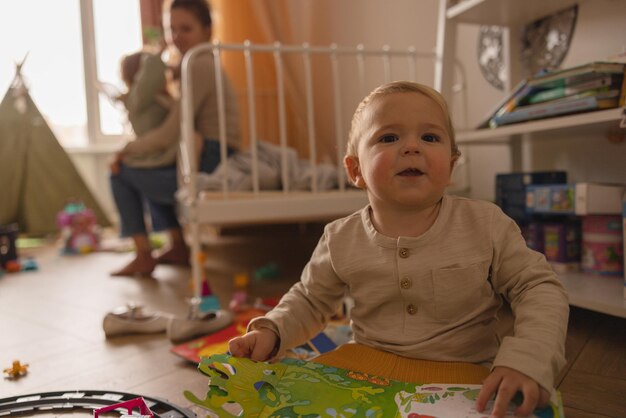 Śliczny kaukaski mały blond chłopiec w domowych ubraniach gra na podłodze w pokoju dziecięcym Koncepcja malucha