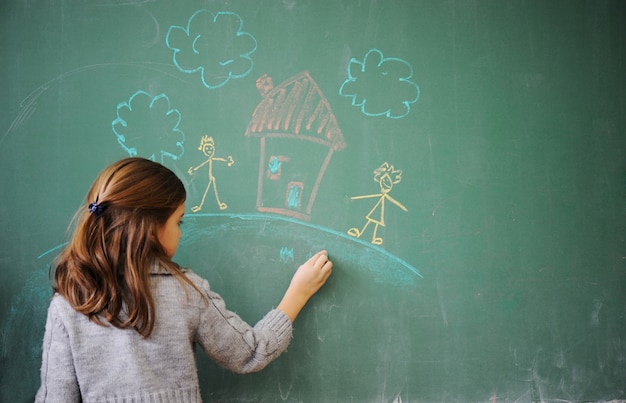 Śliczny mała dziewczynka rysunek na blackboard