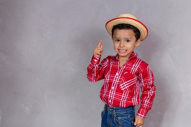 Śliczny mały chłopiec ubrany w typowe ubrania dla Festa Junina z miejscem na kopię